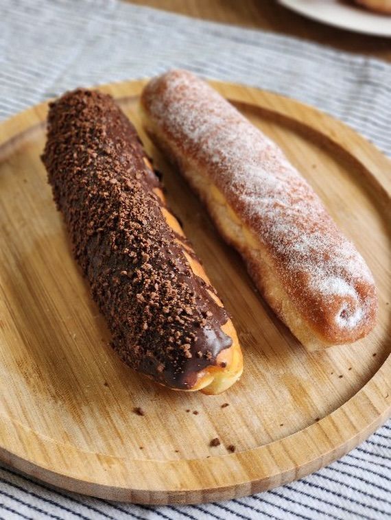 🍩クリームジョーンズとロングジョーンズ🍩

今日は神戸でも朝は雪が降っていました❄️⛄️
寒い日にはおうちでのんびり過ごす方も多いのではないでしょうか。
おやつにもぴったりのパンの中から「ロングジョーンズ」と「クリームジョーンズ」をご紹介します✨

揚げパンにカスタードクリームをサンドして、
砂糖をまぶしたどこか懐かしい味わいの「クリームジョーンズ」。

「ロングジョーンズ」は、「クリームジョーンズ」にチョコレートでコーティングをしたボリューム満点の一品です。

カロリーたっぷり、背徳感もちらりと…？ですが
間違いなく幸せな味わいです☺️
ぜひあたたかいお部屋で頬張ってください！

#ケルンのパン
#ドーナツ